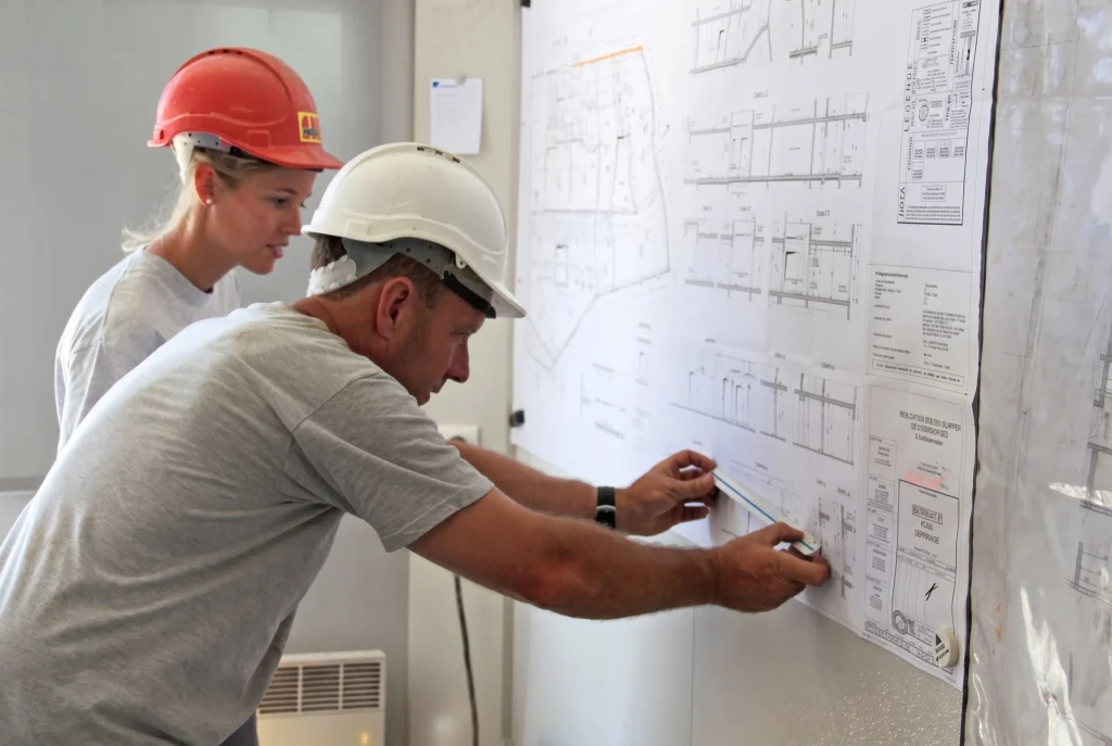 Chef de chantier et compagnon étudiant un plan d'exécution